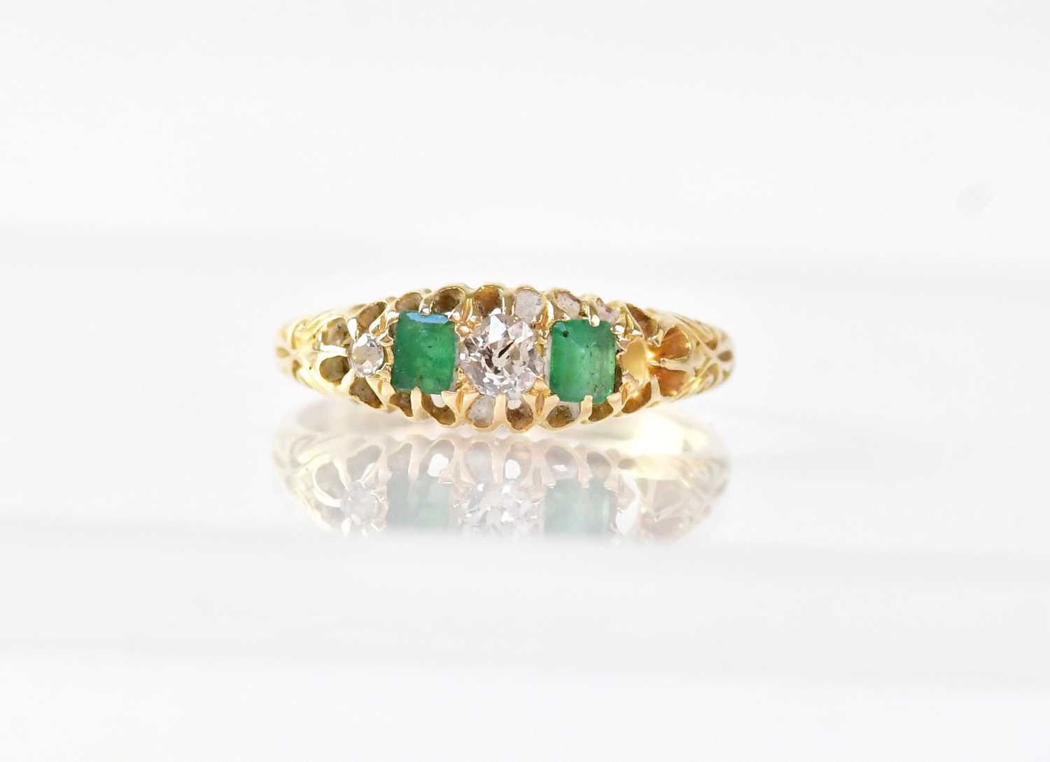 An 18ct gold ring alternately claw set with two emeralds and two diamonds, stamped 18, size N,