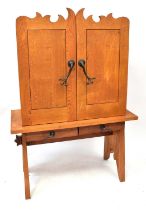 A modern oak cupboard on stand, with two short drawers, with naturalistic style wrought ironwork