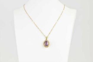 A 9ct gold necklace, length 44cm, and pendant set with claw set oval amethyst, within a border of