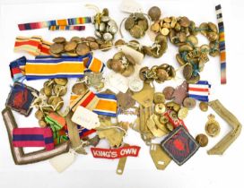 A collection of WWII and other buttons, metal and cloth badges, shoulder stripes, etc.