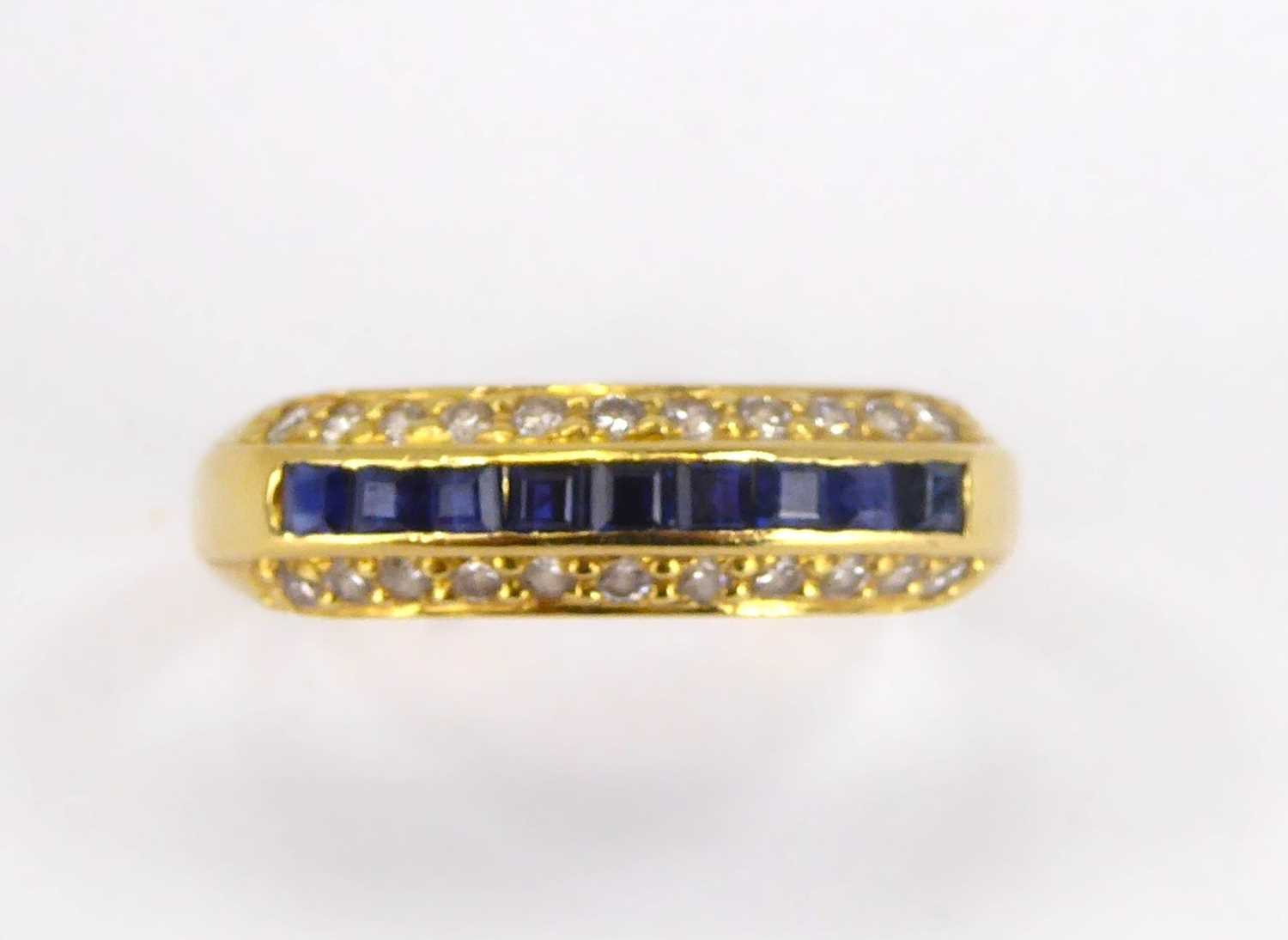 An 18ct gold diamond and sapphire ring, the four central channel set square cut sapphires flanked by - Image 2 of 9