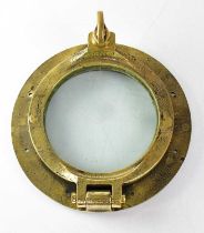 An early 20th century brass porthole and cover, stamped '7NP', diameter 29cm.