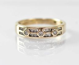 A 9ct gold ring with three collet set diamonds, each flanked by four diamonds in two rows, stamped