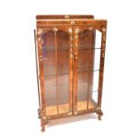 A vintage mahogany two-door display cabinet with three glass inner shelves, glazed sides and