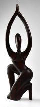 A contemporary dark stained carved wooden figure of a kneeling female, height 78cm (af). Condition