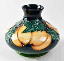 MOORCROFT; a vase decorated with apricots and leaves on a graduated green ground, copyrighted for