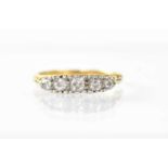 An 18ct gold ring set with five graduated diamonds in a white gold claw setting, stamped 18ct,