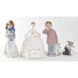 A Royal Doulton figure HN3222 'Kelly', height 19.5cm, a Nao figure of a girl holding a doll, a Nao