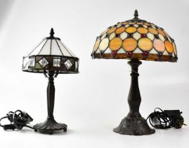 A Tiffany-style leaded and stained glass table lamp on embossed metal column, together with one