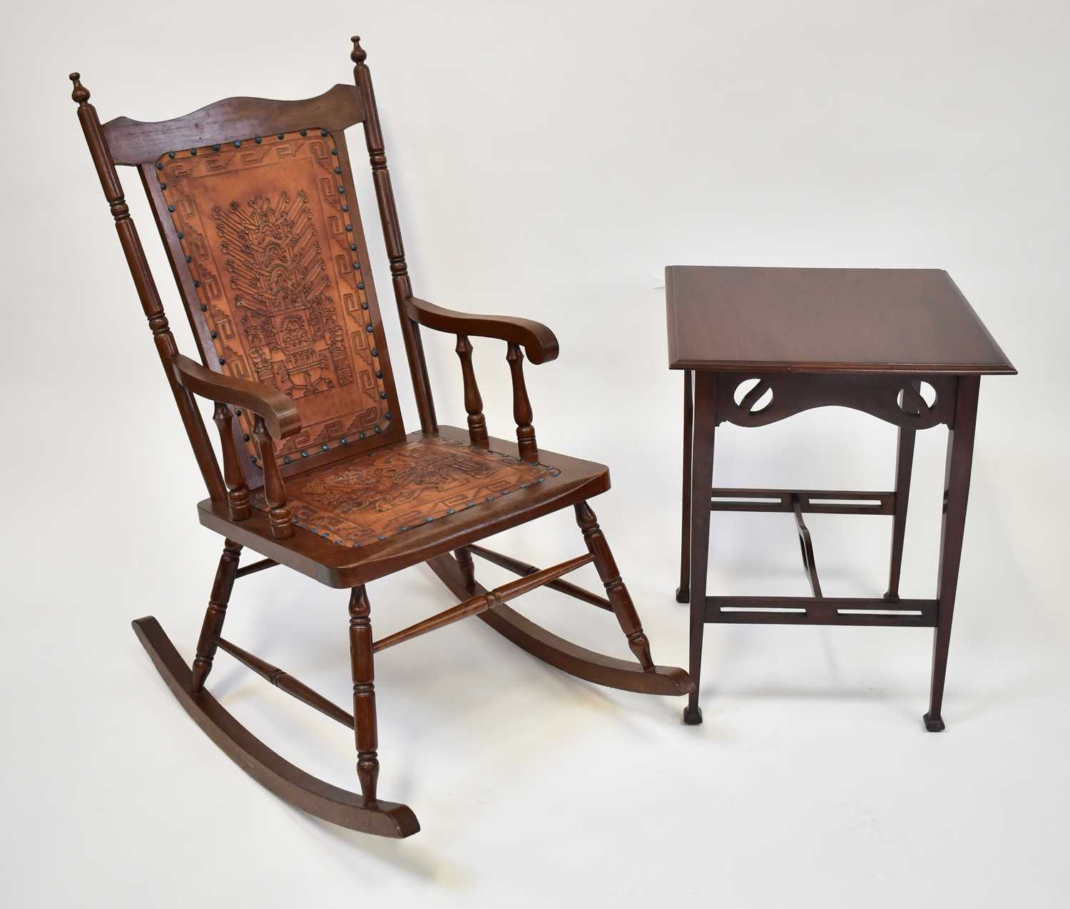 † An American red walnut rocking chair upholstered with tooled leather and studded back and seat,