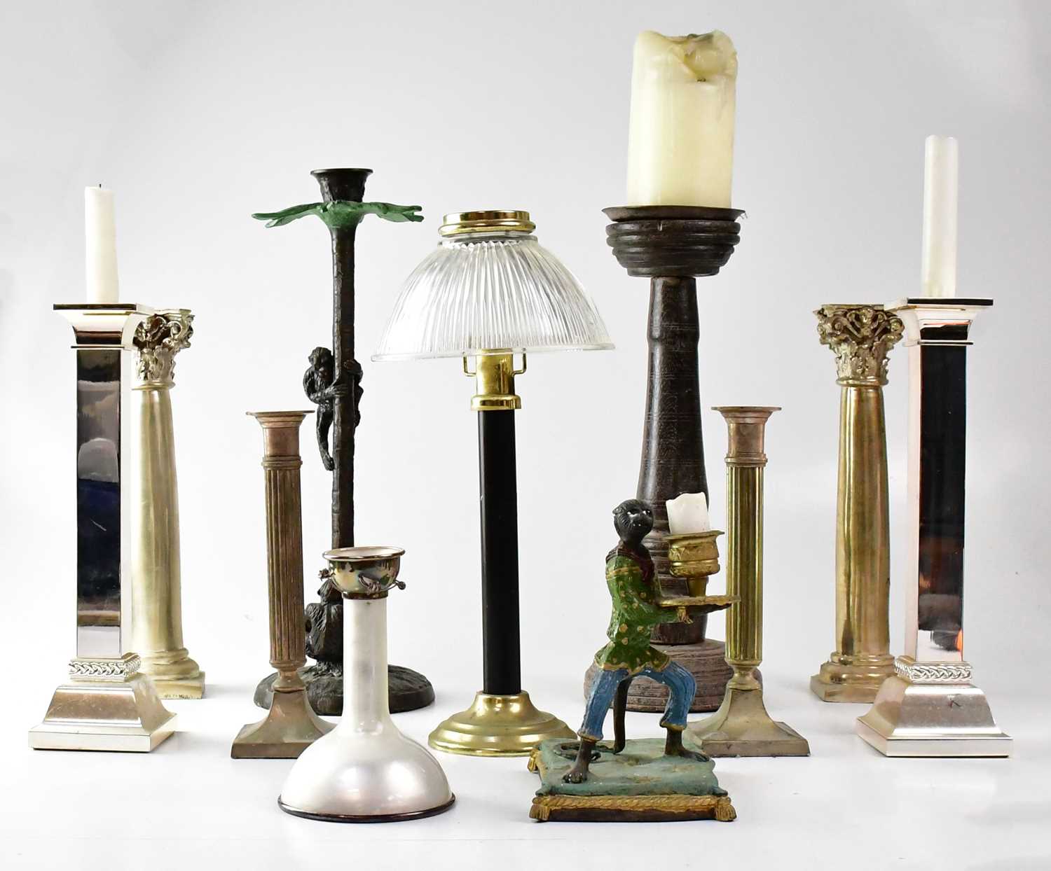 A collection of various candlesticks to include metal monkeys climbing a palm tree, a pair of