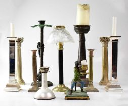 A collection of various candlesticks to include metal monkeys climbing a palm tree, a pair of