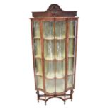 A mahogany William and Mary style glazed display cabinet, with concave and convex glazed panels,