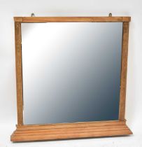 A wall mirror with partial carved floral frame, on a stepped plinth base, with bevelled plate,