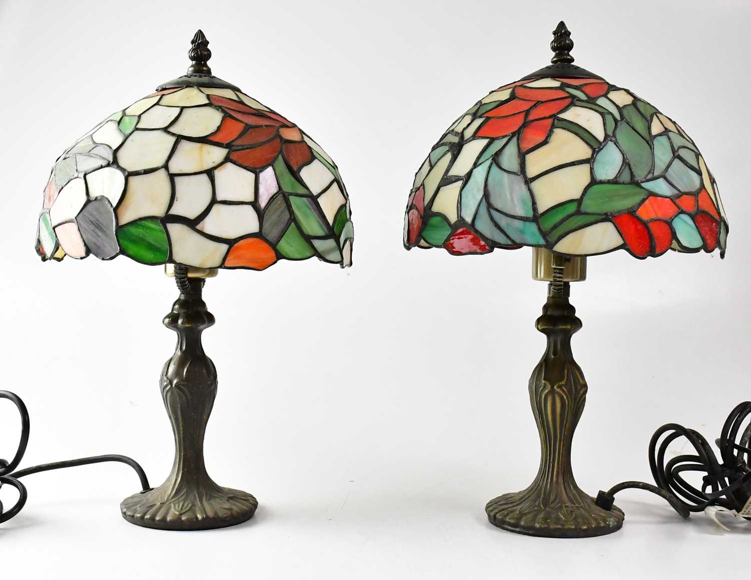 A pair of Tiffany-style leaded stain glass table lamps, on embossed metal columns, height 41cm (