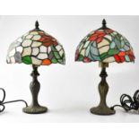 A pair of Tiffany-style leaded stain glass table lamps, on embossed metal columns, height 41cm (