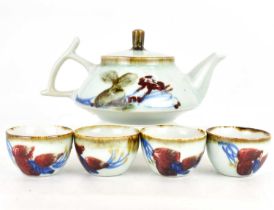 A modern Japanese sake teapot, 12 x 22cm, and four tea bowls, 4.5 x 7cm, marked to the underside