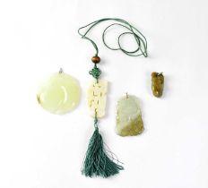 A green jade circular pendant carved with a pair of peaches on a white metal mount, diameter 5.