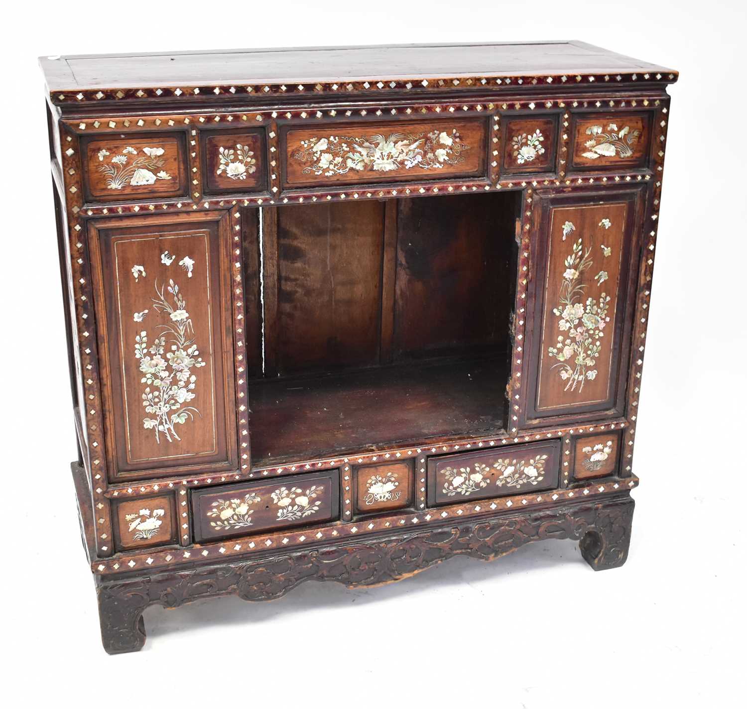 An early 20th century Chinese stained hardwood mother of pearl inlaid side cabinet, with carved