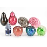 Eight glass paperweights to include pear, apple, snail shells, faceted sphere, and one with two fish