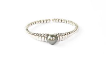 MAUBOUSSIN; an 18ct white gold beaded bangle, set with a cultured grey pearl, diameter approx.