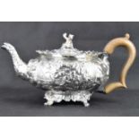 A George III hallmarked silver teapot with all-over Oriental and floral pattern extending to spout