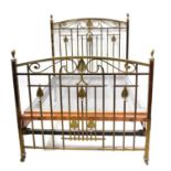 An Art Nouveau brass double bedstead with stylised leaf motifs, arched headboard and foot rail, to