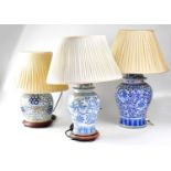Three Chinese blue and white table lamps in the form of Ginger jars, two on turned wooden bases,