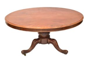 A Victorian mahogany oval tilt-top loo table on bulbous carved base with tripod cabriole legs, 72