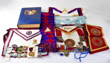 A collection of Masonic regalia, to include aprons, cuffs for QEII Lodge, books, a Bible, jewels and