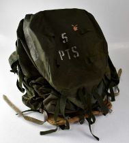 A 1970s military issue rucksack with black painted metal A-frame and white leather straps, marked to