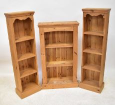 A pine bookcase of three shelves with reeded supports, 107 x 59 x 22.5cm, together with a pair of