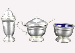 A three-piece hallmarked silver cruet comprising pepperette, salt with blue glass liner and