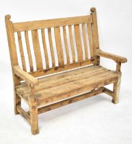 A late 19th/early 20th century pine bench with bowed back splats, slatted seat, with pegged joints