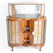 A 1950s mahogany veneered cocktail cabinet, the upper section with cocktail design mirrored back,