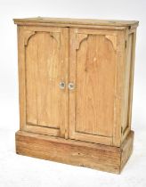 An early 20th century pine miniature wardrobe, lift-up front top section releasing two panel doors