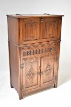 JAYCEE FURNITURE LTD; a 20th century oak cocktail cabinet with cantilever top, the fall-front with