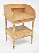 A late 19th/early 20th century pine washstand with three sides and shallow shelf above central