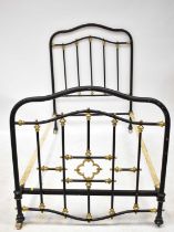 A late 19th/early 20th century cast metal and brass single bed, in the Gothic style, raised on pot