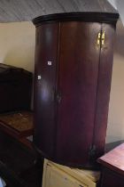 A Georgian mahogany bowfront corner cupboard.