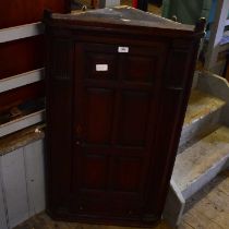 A 19th century oak and burr oak hanging corner cupboard, with single panelled door enclosing fixed