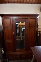 A Victorian pitch pine wardrobe with moulded cornice above a single mirrored door and two base
