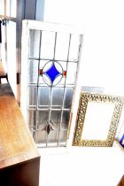 Two leaded stained glass panels within painted frames, 107 x 45cm, together with a brass wall mirror