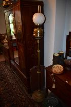 A Victorian brass adjustable oil lamp with associated milk glass shade and chimney, on column