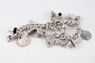 A vintage silver charm bracelet with assorted novelty charms (94g)