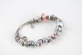 A silver bracelet filled with assorted charms, by Pandora (80g)
