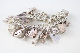 A vintage silver charm bracelet with assorted novelty charms (96g)