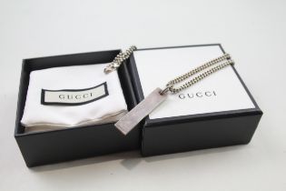 A silver dog tag necklace by Gucci