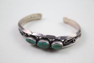 A silver turquoise set artist signed Native American made bangle