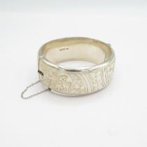 A chunky hallmarked silver cuff bangle with safety chain 43g